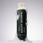 Bottle of Keratin Shampoo with foam on a gray background